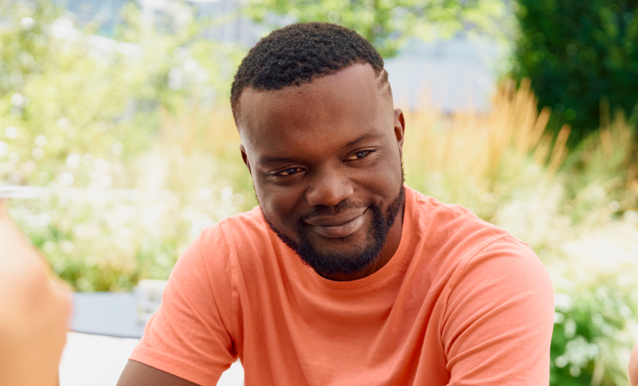 Man in orange t-shirt smiling